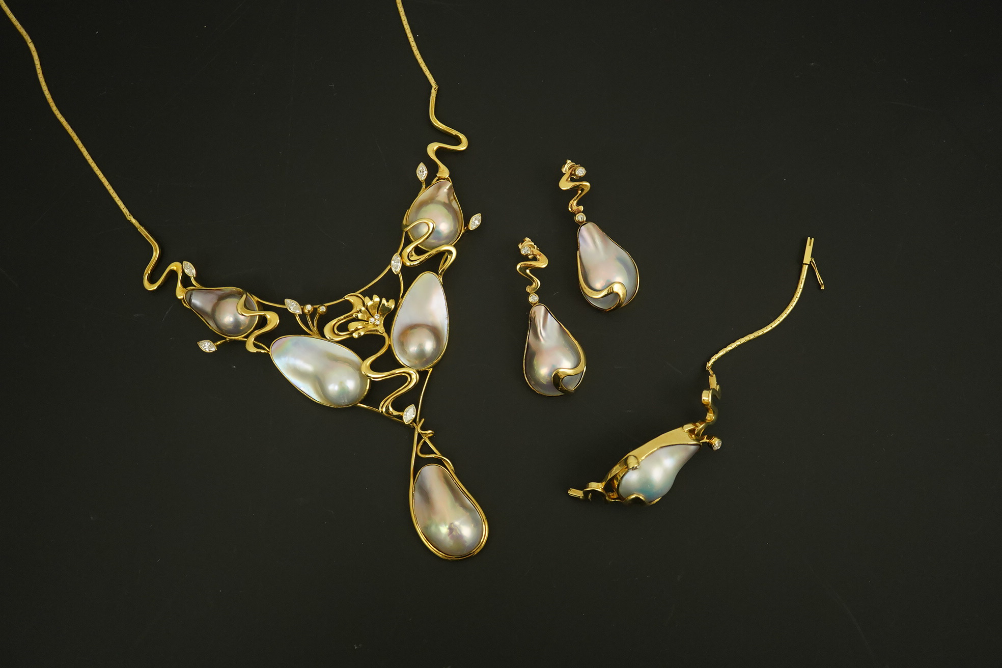 A modern suite of 18k gold, baroque pear, round and marquise diamond set jewellery